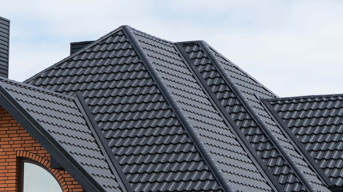 Toit d'une maison en panneaux tuiles gris.