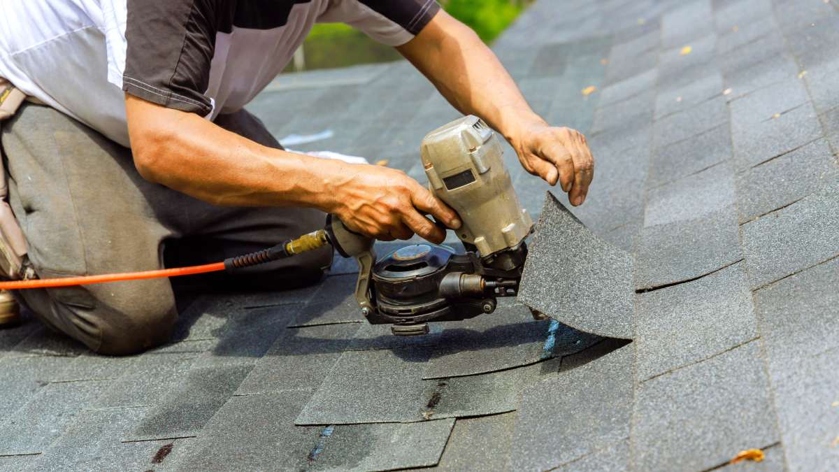 Installation d'une toiture en shingle par un couvreur.