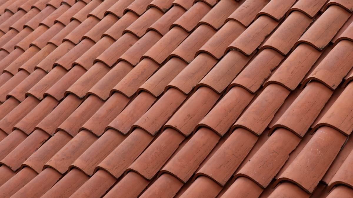 Tuiles de toit en terre cuite avec profil incurvé.