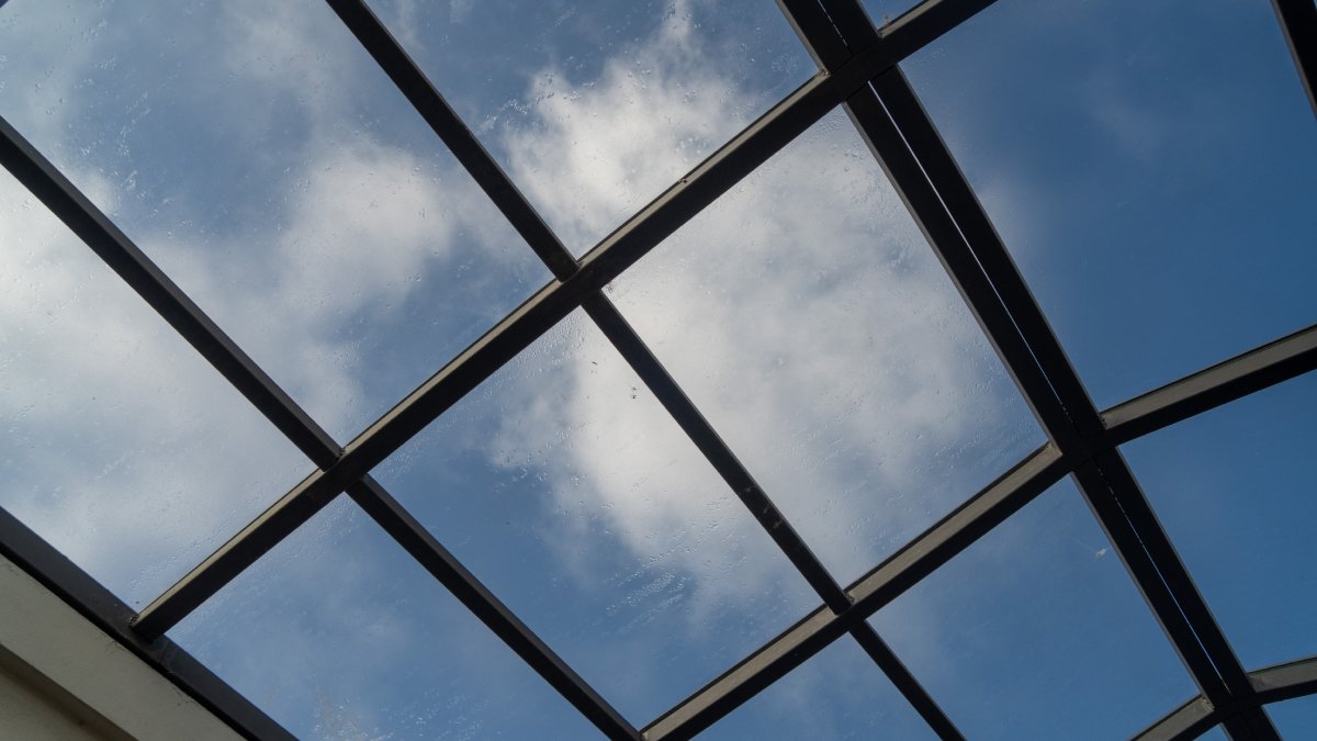 Verrière en gros plan avec ciel bleu et nuages.