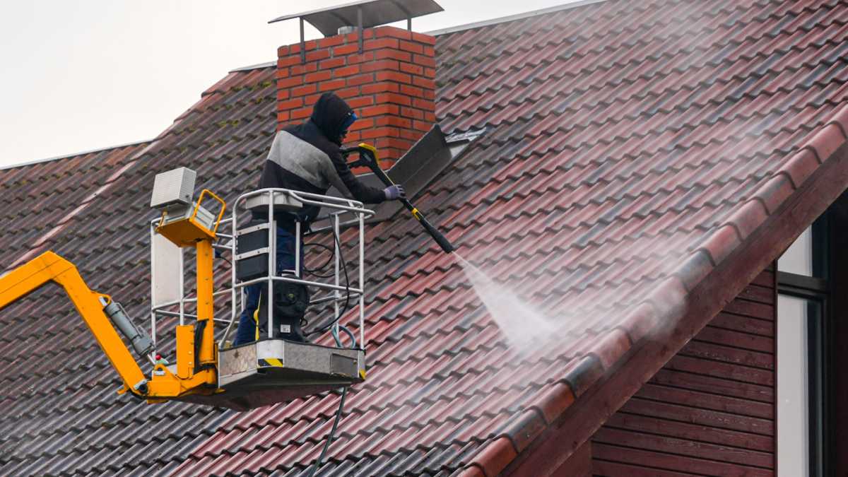 Ouvrier nettoyant une toiture en Belgique.