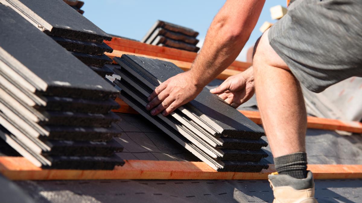 Travaux de toiture en cours comme nouveau revêtement de toit en tuiles fait par le couvreur.