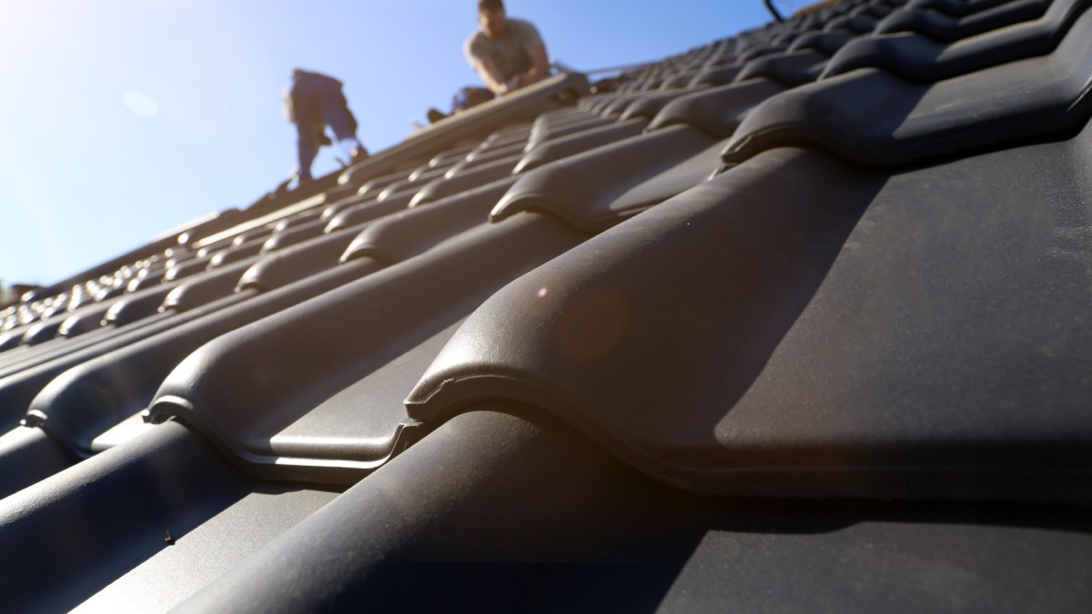 Travaux de toiture, nouveau revêtement d'un toit en tuiles.