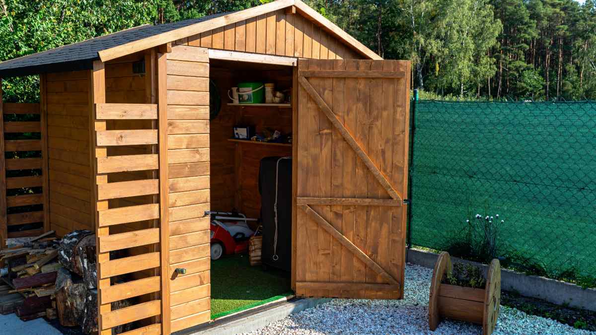 Abri de jardin en bois avec sa porte ouverte. L'intérieur est visible.