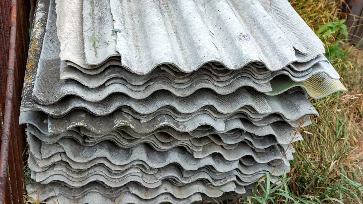 Une pile de vieilles feuilles de ciment d'amiante ondulé.