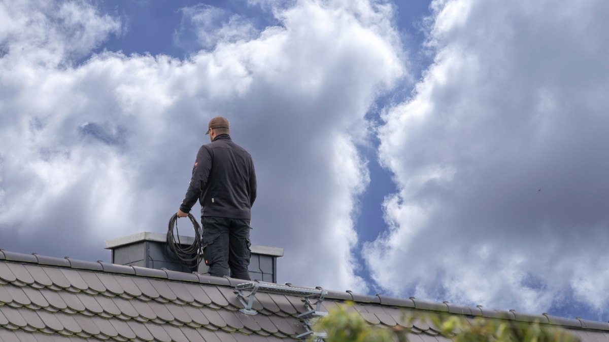 Ramoneur sur la toiture d'une maison en Belgique.