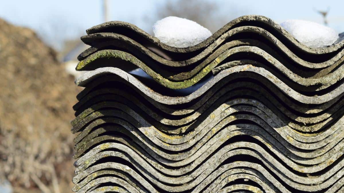 Pile de vieilles tuiles en amiante posées dehors durant l'hiver.